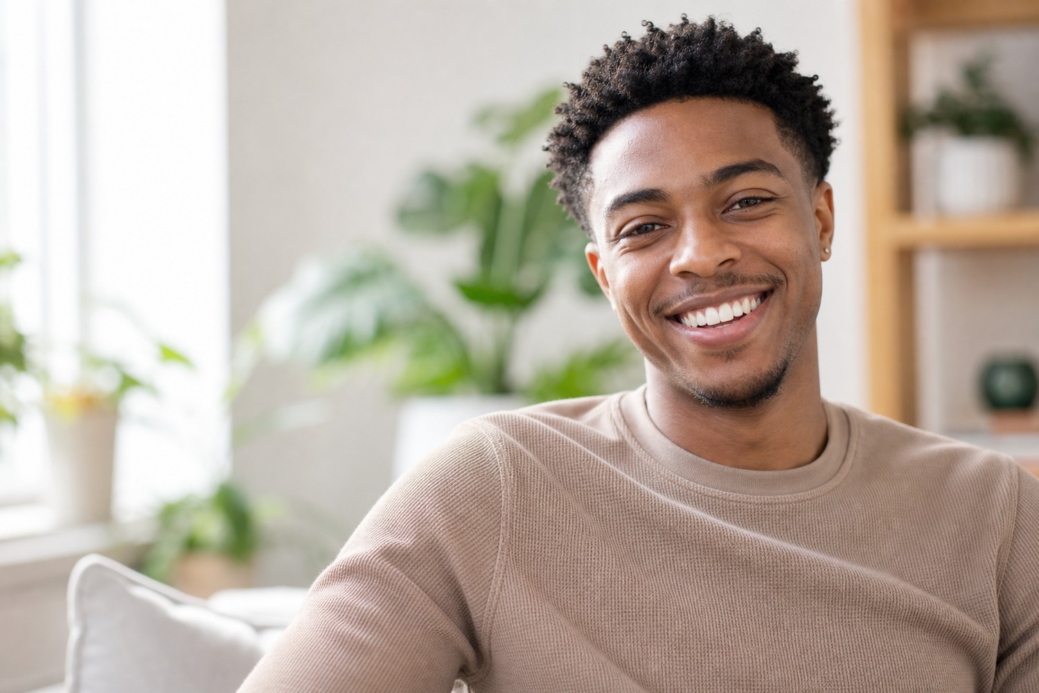 A happy young man with a beautiful, natural straight smile at home
